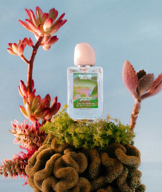 Perfume bottle labeled "Floating Forest" on exotic plant with blue background