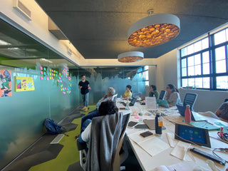 August 2021. A large group of the team sitting in a conference room. Lots of post it notes. This was one of the earliest team brainstorms we had.